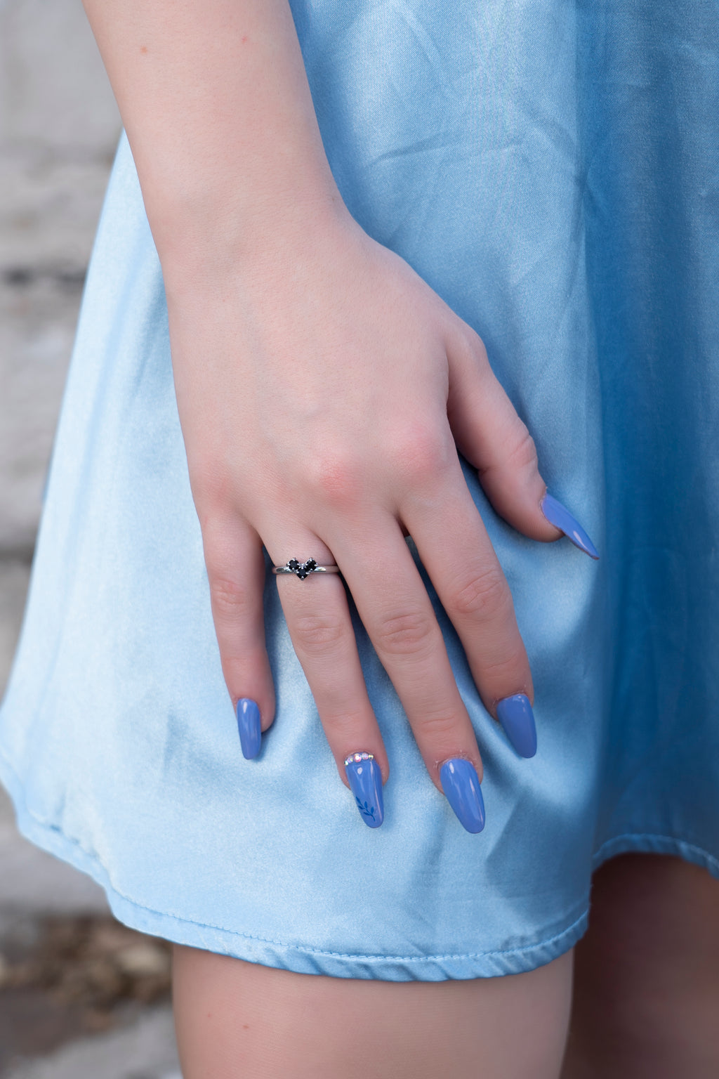 Dettaglio anello a cuore con cristalli Swarovski neri indossato da modella 