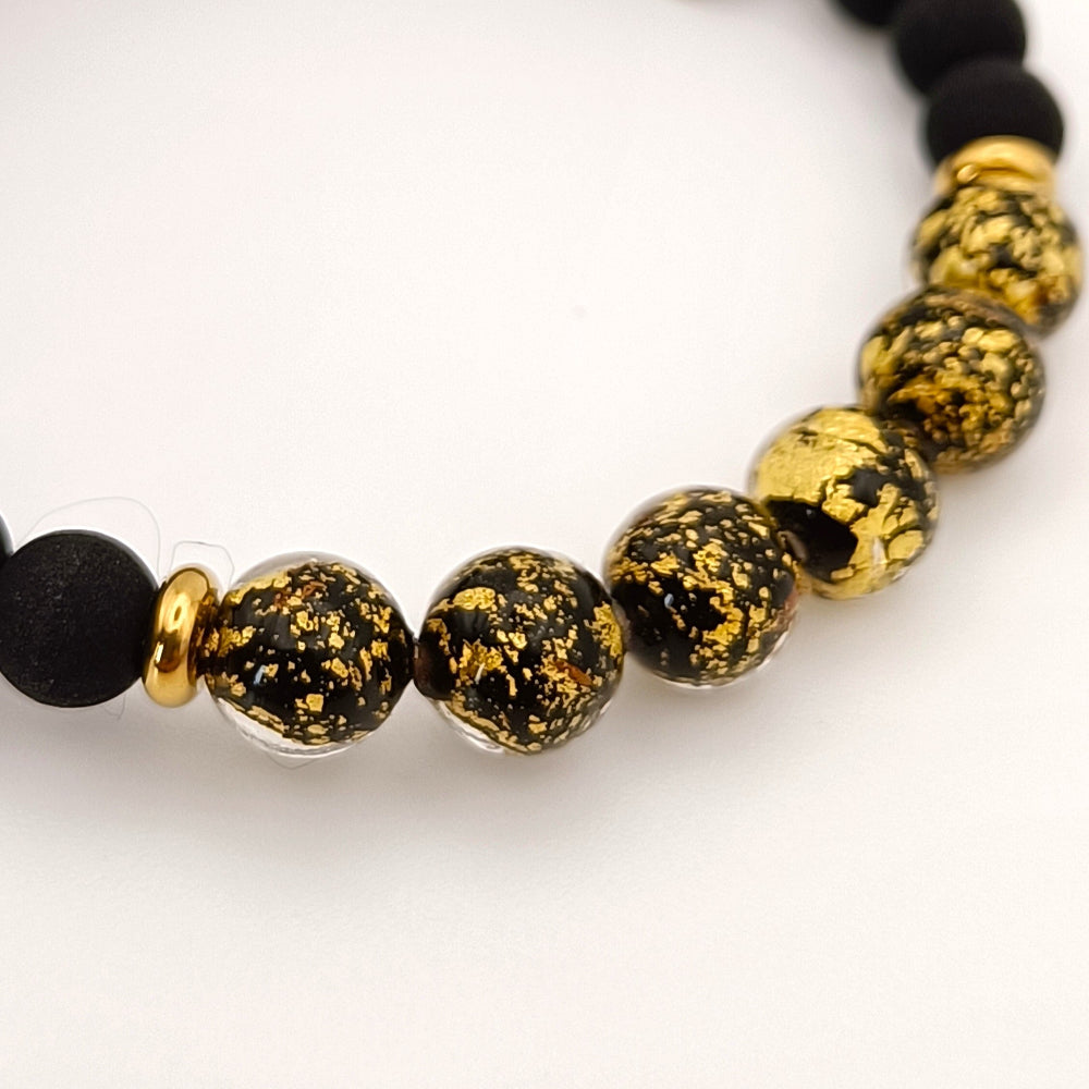 Dettaglio ravvicinato bracciale con pietra lavica nera e vetro di Murano con filigrana oro - artigianato italiano