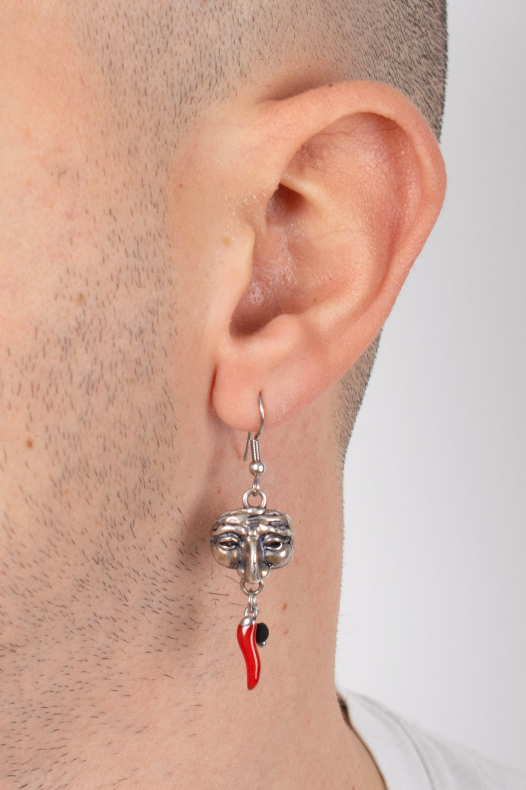 Orecchini pendenti unisex maschera pulcinella in metallo con corallo rosso e perla nera su sfondo bianco