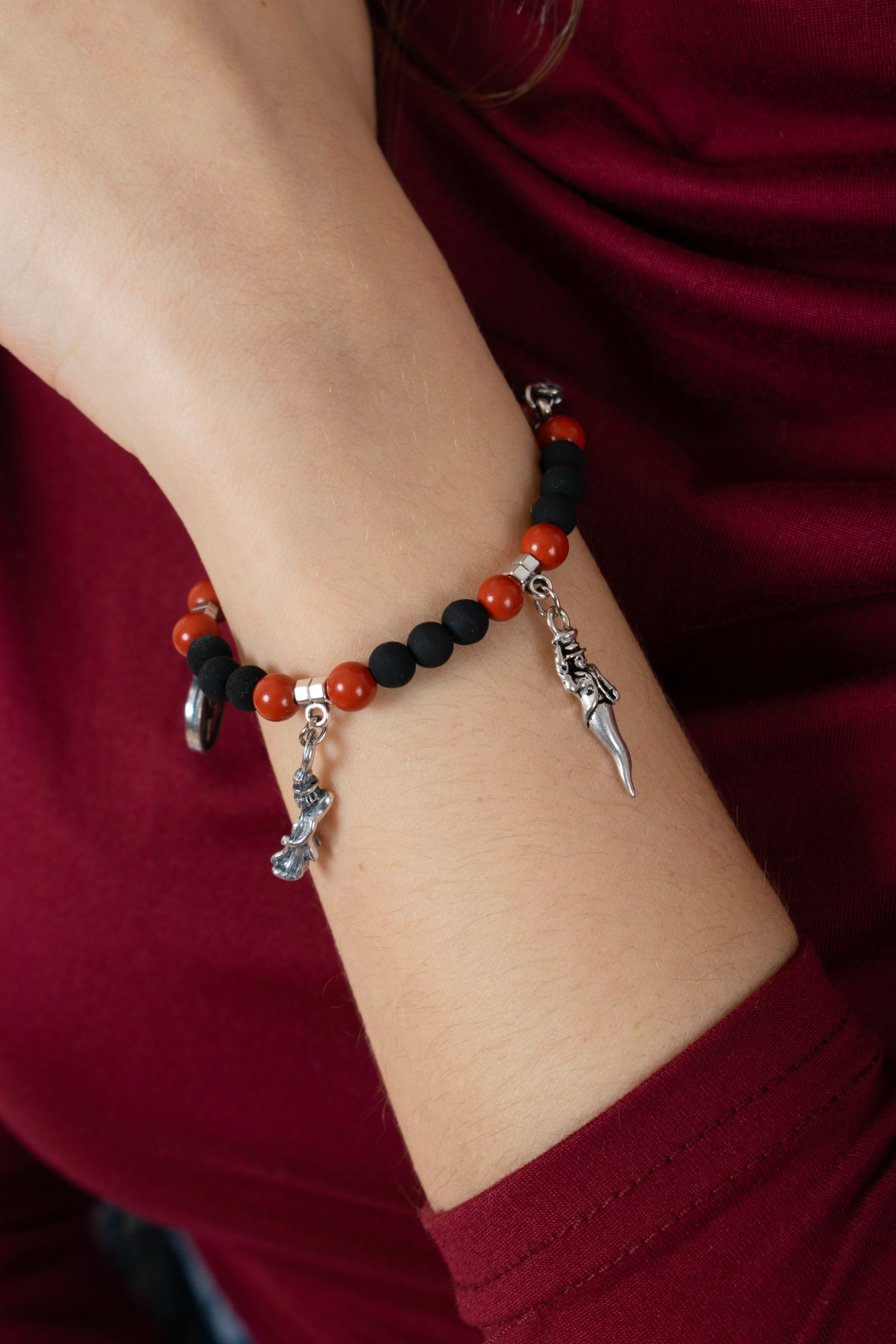 Bracciale Anima Partenopea con pietra lavica del Vesuvio e diaspro rosso indossato al polso con charm napoletani in acciaio
