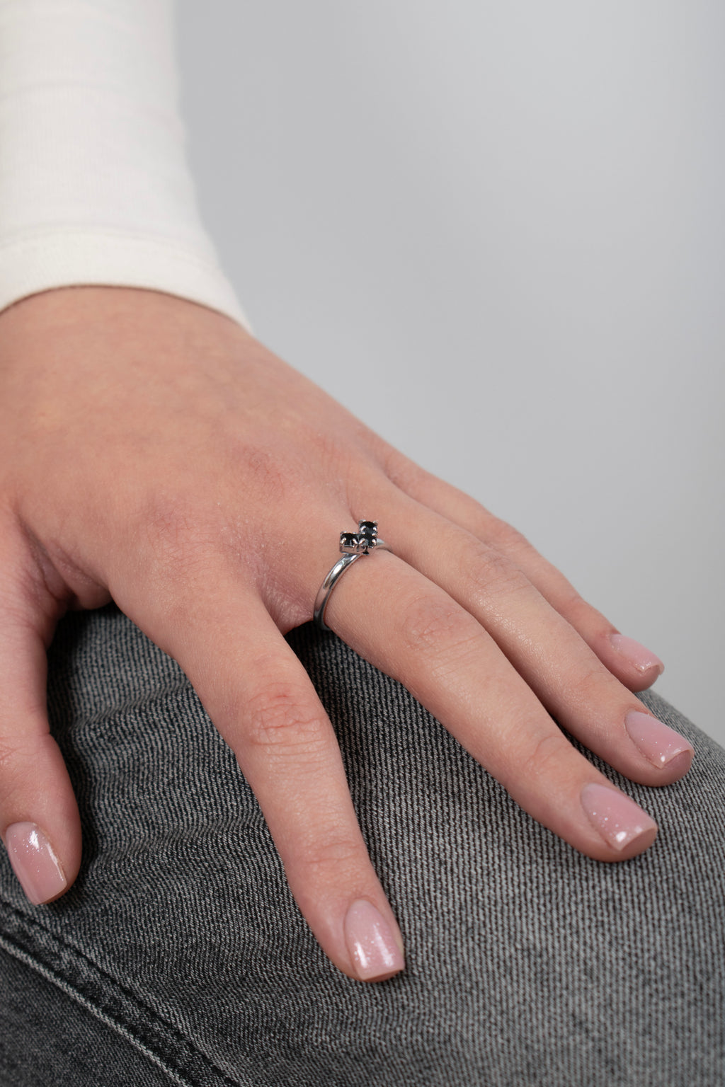 Dettaglio anello con pietra nera e montatura argentata indossato - vista ravvicinata su mano donna