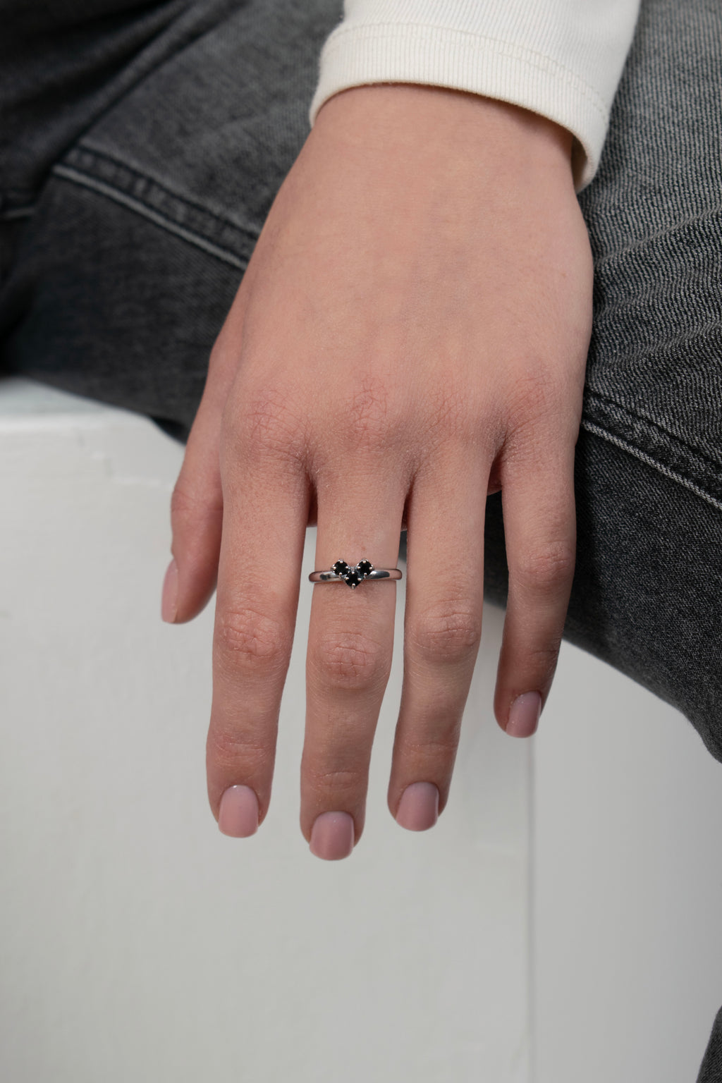 Donna indossa anello con pietra nera centrale e dettagli argentati - gioiello elegante su mano femminile