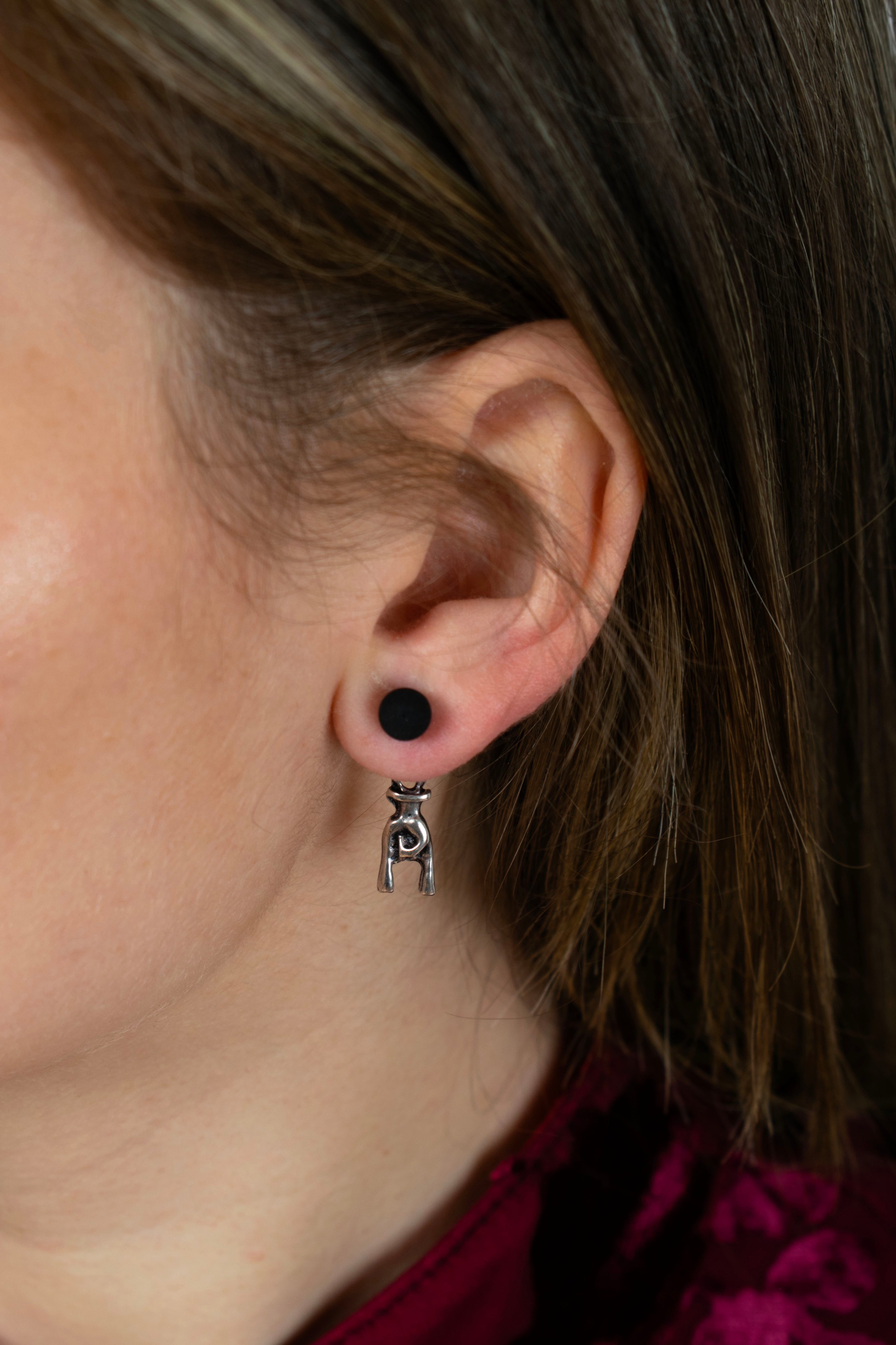 Dettaglio orecchini corna portafortuna indossati, amuleto italiano in metallo