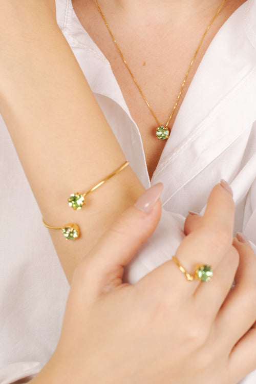 Modella indossa collana dorata con cristallo Swarovski verde - gioiello donna elegante made in Italy