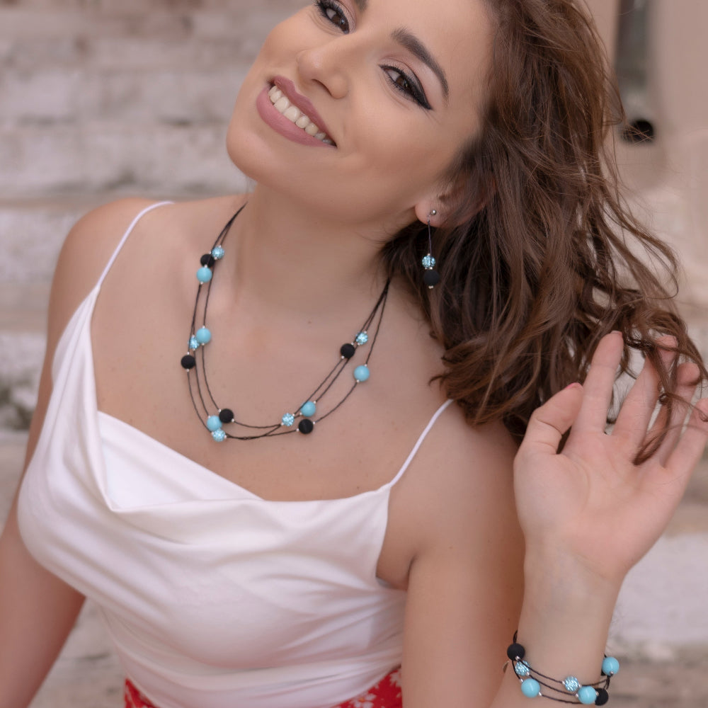 Modella indossa set di gioielli con collana, bracciale e orecchini in pietra lavica e cristalli Swarovski