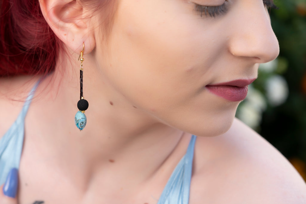 Eleganti orecchini fatti a mano con vetro di Murano azzurro e pietra lavica nera, perfetti per ogni occasione.