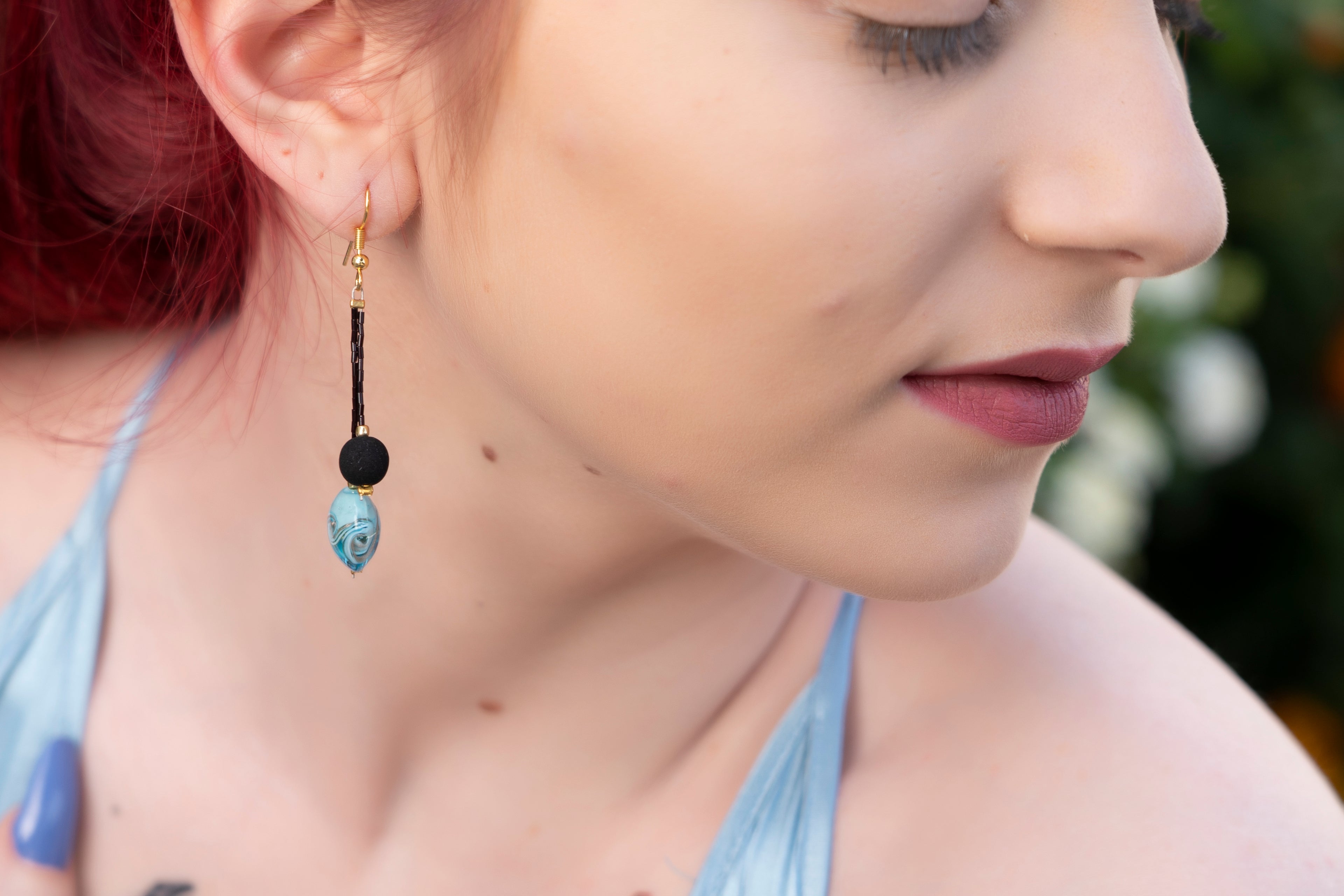 Eleganti orecchini fatti a mano con vetro di Murano azzurro e pietra lavica nera, perfetti per ogni occasione.