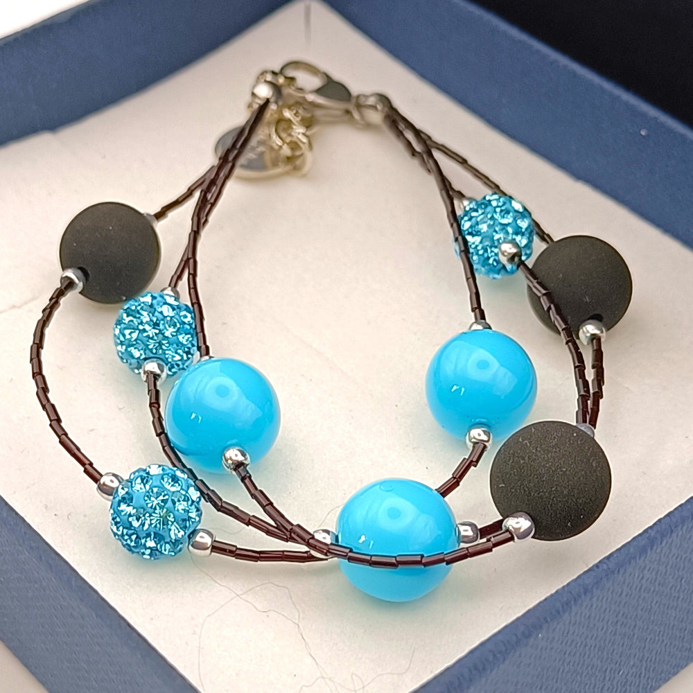 Bracciale con perle nere in pietra lavica sintetizzata e cristalli Swarovski azzurri - ungioielloperte