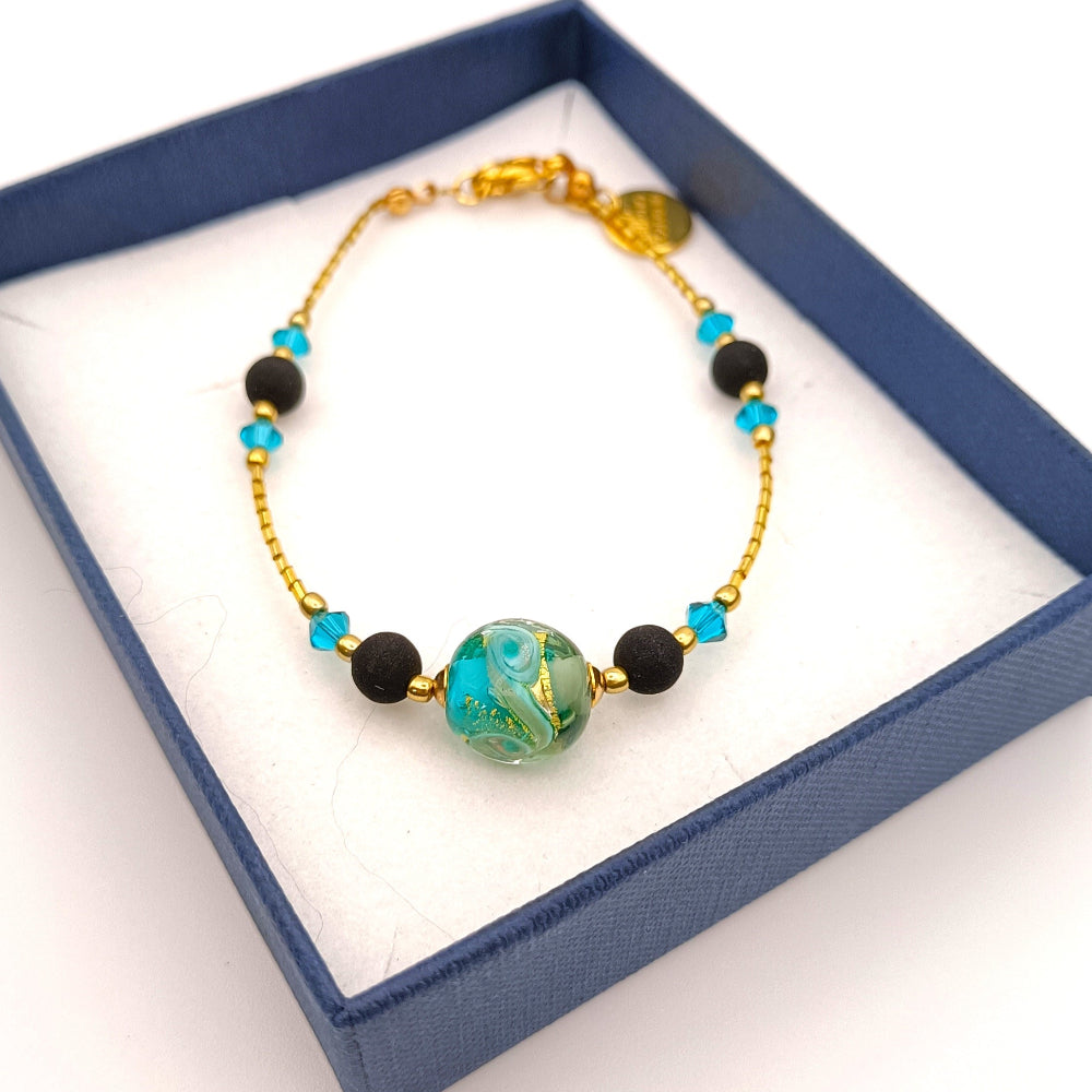 Bracciale di ungioielloperte.com con perle in pietra lavica, perla in vetro di Murano verde e cristalli Swarovski confezione