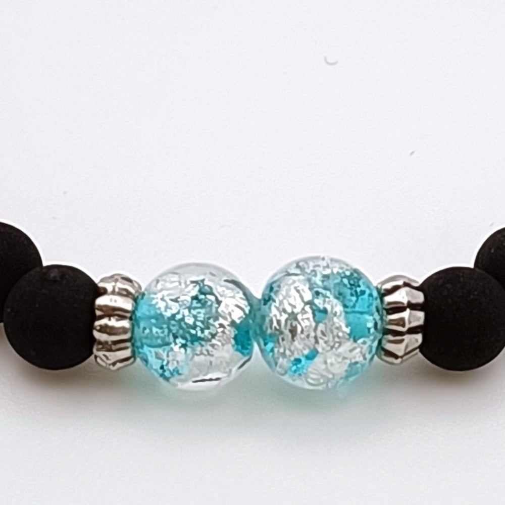 Dettaglio bracciale artigianale di ungioielloperte.com con perle in vetro di Murano azzurre e dettagli in argento