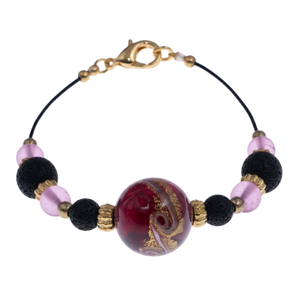 Dettaglio del bracciale di Giamas con perla centrale in vetro di Murano rosa, perle in pietra lavica e dettagli in metallo dorato