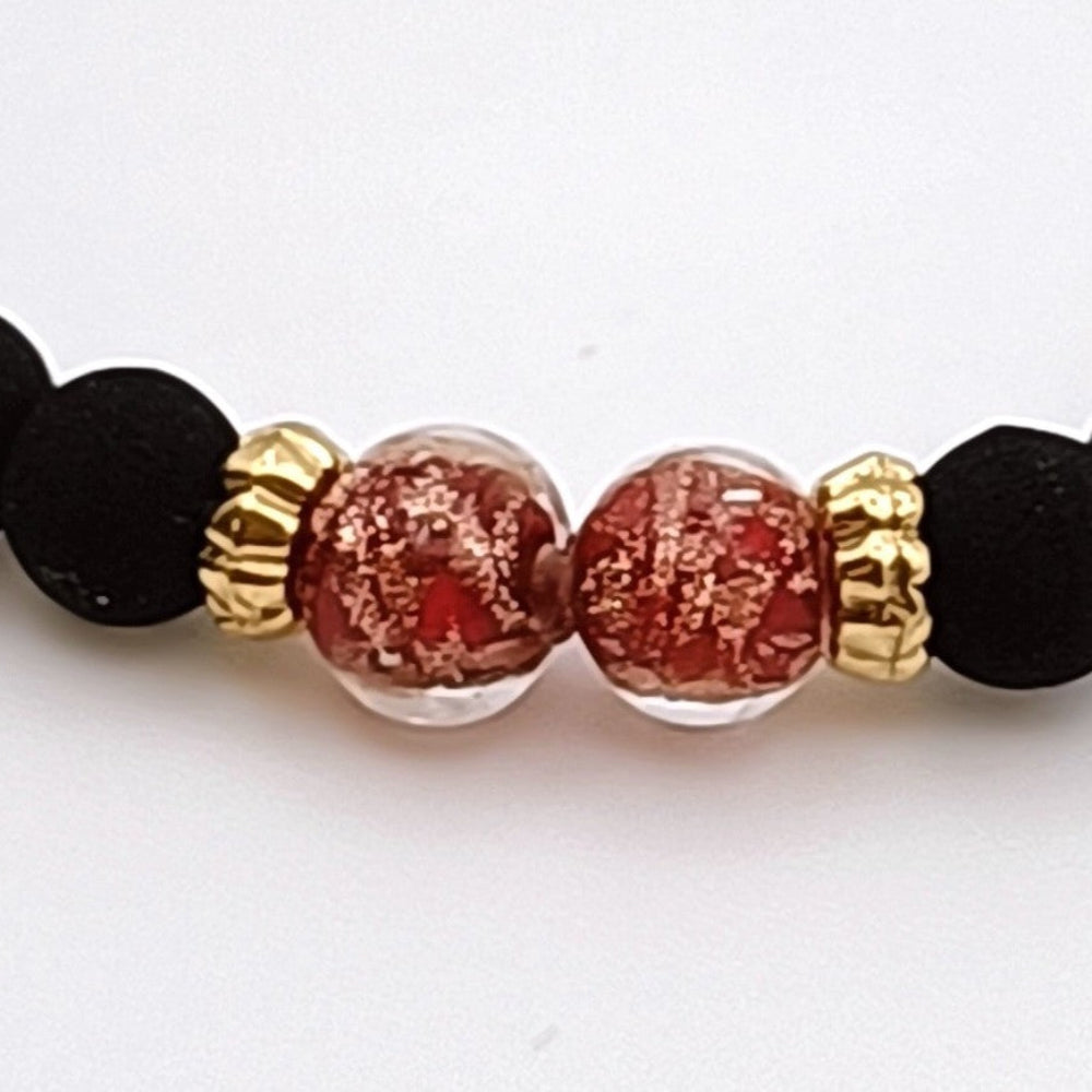 Dettaglio bracciale artigianale di ungioielloperte.com con perle in vetro di Murano rosso e dettagli in oro