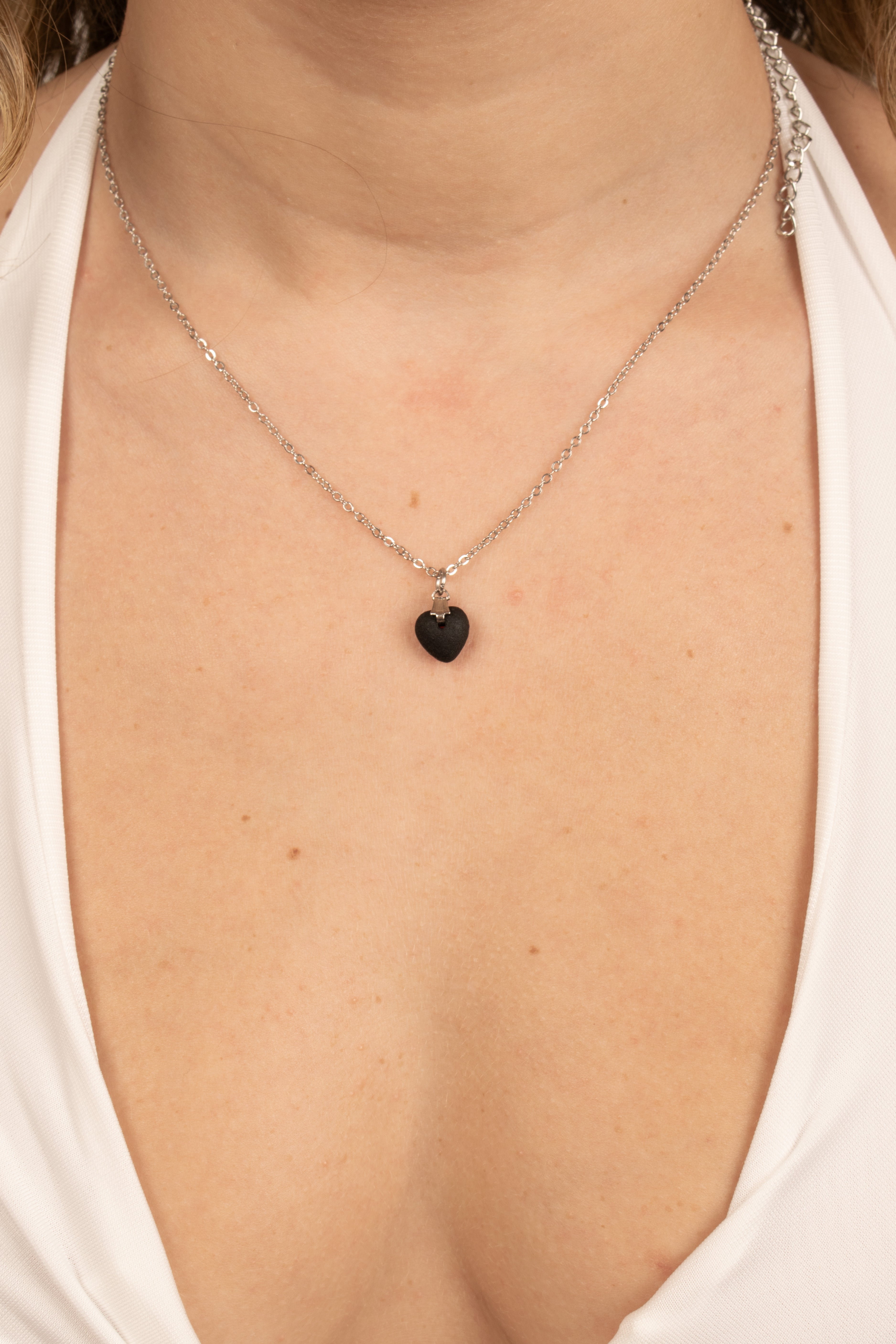 Donna indossa collana con ciondolo cuore nero lucido e catena argentata - gioiello romantico ed elegante