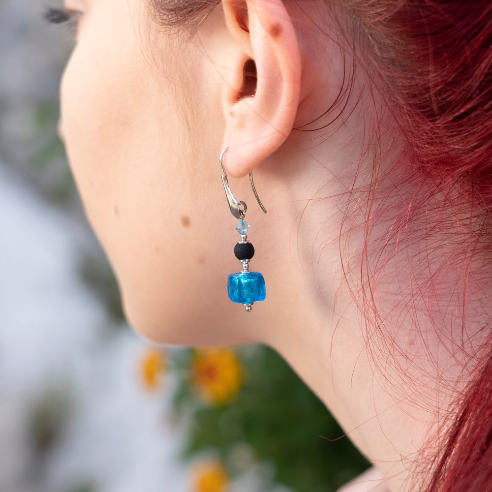 Modella indossa orecchini in argento italiano con pietra lavica e Murano - ungioielloperte