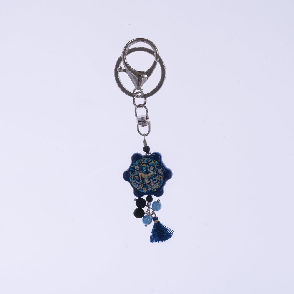 Portachiavi ceramica blu con nappa tessile e chiusura moschettone - vista laterale design mediterraneo