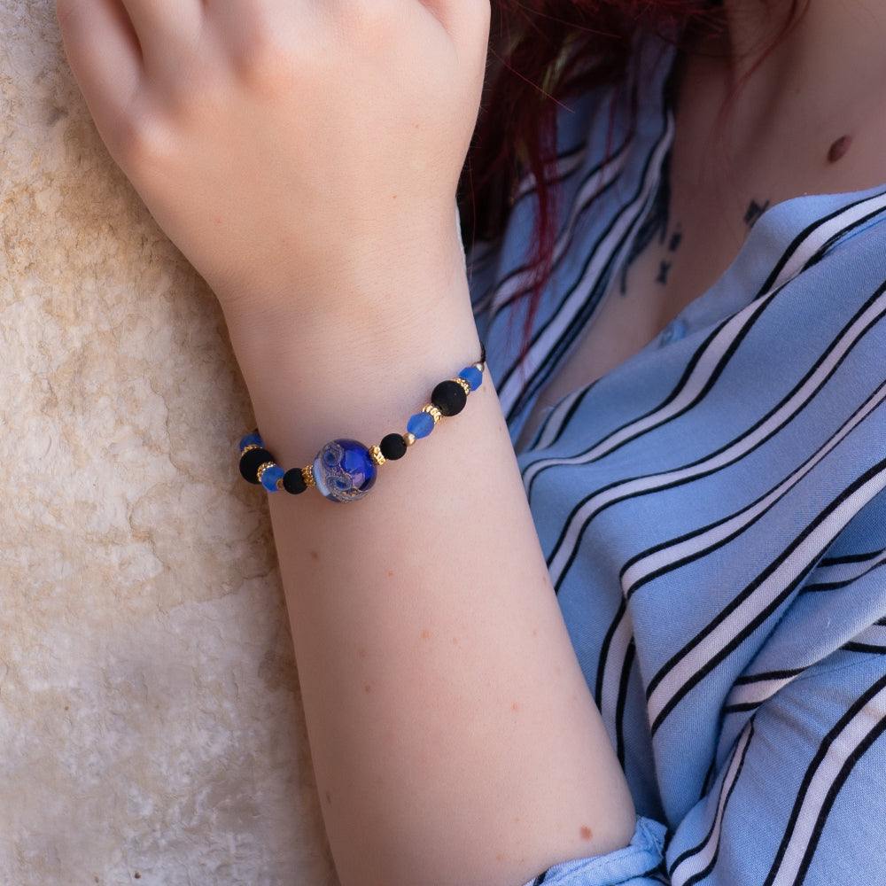 Modella indossa bracciale di Giamas.it con perla centrale in vetro di Murano blu e dettagli in metallo dorato